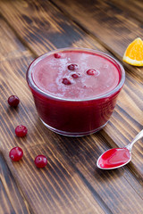 Wall Mural - Cranberry sauce in the glass bowl on the  brown wooden  background. Location vertical.
