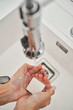 © PHILIPPE DEGROOTE/ADDICTIVE STOCK - Woman washing her hands on the kitchen sink to avoid possible infection