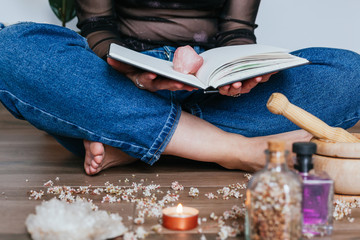 Close-up of a woman reading a book with a rose quartz on top