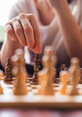 Pensive woman plays chess