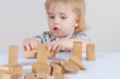 © got - kid toddler playing wooden toys at home or nursery on light background.