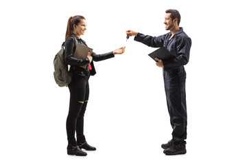 Auto mechanic giving car keys to a young female