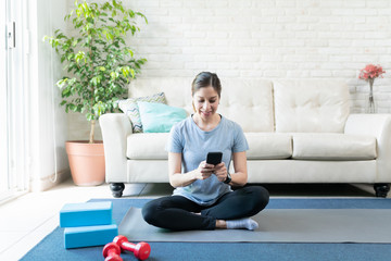 Wall Mural - Using a smartphone and working out at home