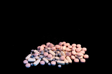 many pills on a black background, addiction, medicine and dependency concept