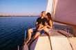 © VlaDee - Couple on the sailing boat drink champagne in a sea at sunset
