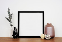 Mock Up Black Square Frame With Home Decor And Eucalyptus Branch. Wooden Shelf Against A White Wall. Copy Space.