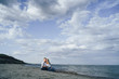 © Daria - Lifestyle romantic evening for two. Young lovers went on a trip to the sea. Sitting on the sand in the evening sun and hugging, talking, kissing and enjoying the absence of people around.