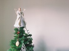 Angel On Christmas Tree Top Against Wall