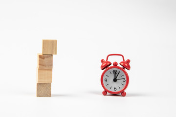 Man hand with wooden block and Red retro alarm clock with reflection on a white background