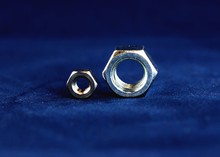 Close-up Of Steel Nuts On Blue Background