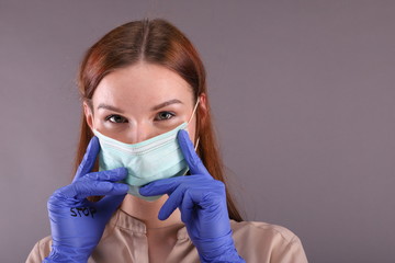 Woman wears a Surgical mask for protect Covid-19 (coronavirus) and looks at camera