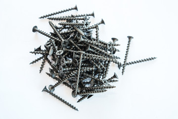 Wall Mural - The black screws. Black screws are piled on a white background.