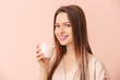 © Pixel-Shot - Young woman with tasty yogurt on color background