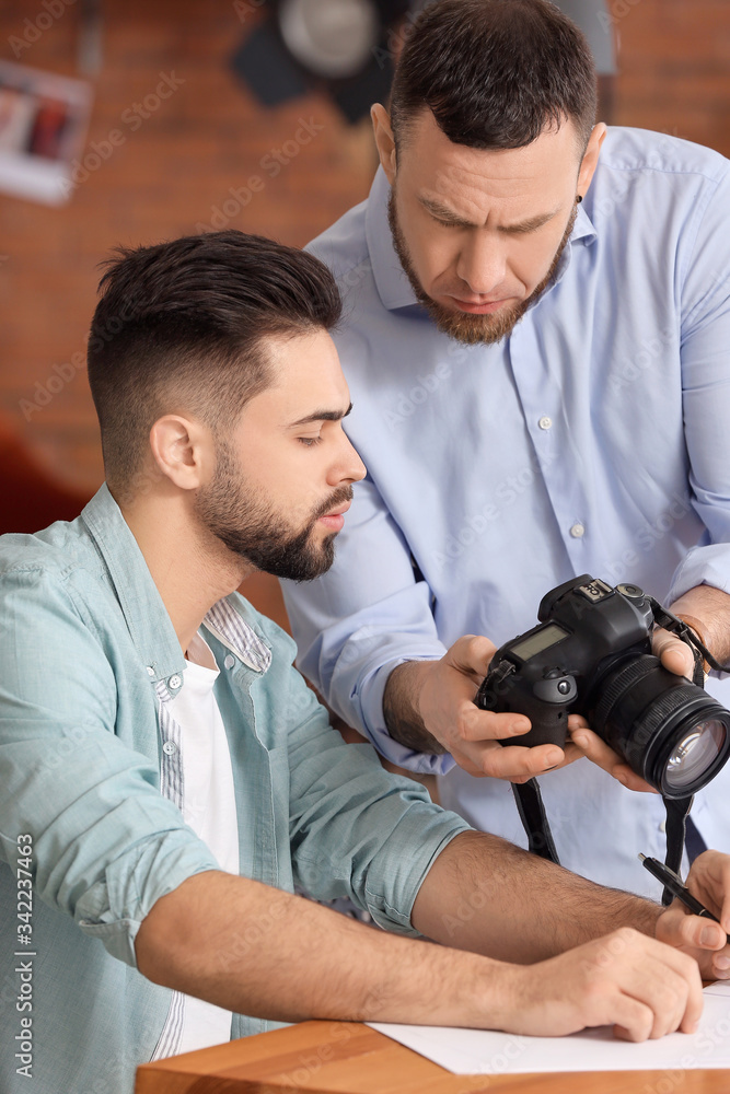 Mentor teaching young photographer in studio