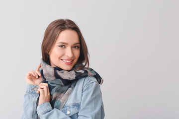 Wall Mural - Beautiful young woman with stylish scarf on grey background