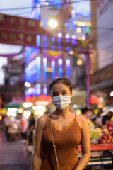 Wall Mural - Young Asian tourist woman wearing mask for protection from corona virus outbreak in Chinatown at night