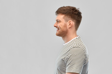 Sticker - people concept - smiling young man in striped t-shirt over grey background