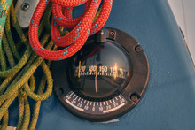 Closeup Sailing Yacht Compass And Red And Green Ropes. Sailing At Sunset. Yachting Concept And Sea Background