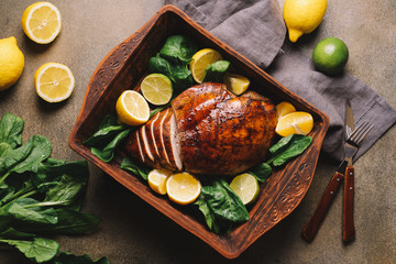 Roasted turkey breast in ceramic tray decorated with citrus fruits. Festive dinner Meat Dish