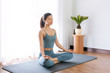 © 出 小 - A young Asian woman practicing yoga indoors