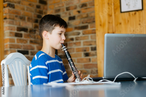 Fotografía Boy with a clarinet plays music. Online music lesson concept