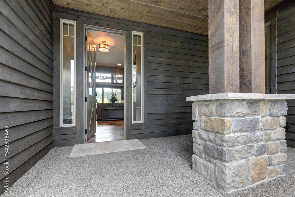Grey new beautiful rustic home front door and entrance exterior with open door and lights on. - obrazy, fototapety, plakaty 