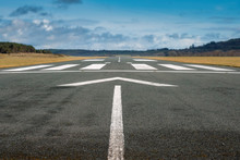 Small Airport Asphalt Runway With Markings For Landings. Blue Cloudy Sky And Fields Around. Nobody.