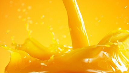 Fototapete - Orange juice splash on coloured background