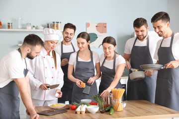 Canvas Print - Female chef and group of young people during cooking classes