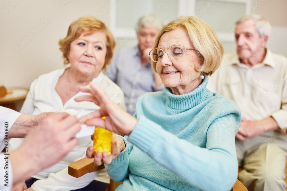 Verteilt Arzt verteilt Tabletten an eine alte Frau im Gesundheitskurs im ...