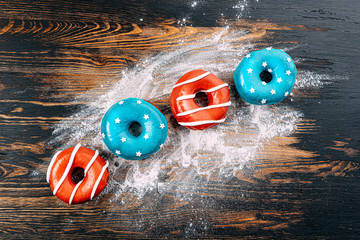 donuts one with blue icing and white stars and with red icing and white stripes