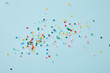 canvas print picture - Top view of colorful confetti scattered on blue background