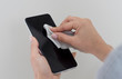 © Hazal - Cleaning the smartphone screen with a fiber cloth from dirt dust and other external factors. Mobile Care Concept