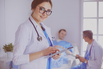 Female doctor using tablet computer in hospital lobby