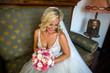 © hreniuca - Beautiful blonde bride posing in wedding dress with bouquet of flowers in hand