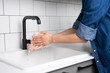 Man Washing Hands in the Kitchen with Warm Running Water