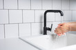 Man Washing Hands in the Kitchen with Soap and Warm Running Water