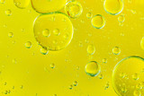 Fototapeta Łazienka - Beautiful and fantastic macro photo of water droplets in oil with a yellow background.