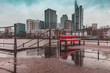 Frankfurt skyline and bench reflection in rain puddle