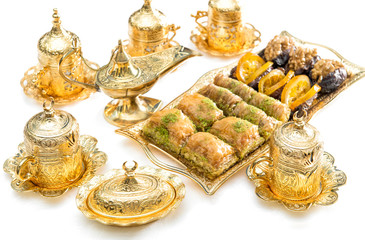 Wall Mural - Arabic food delight tea cups golden dishes Ramadan kareem