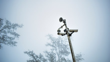 Low Angle View Of Megaphone And Security Camera Against Sky During Foggy Weather