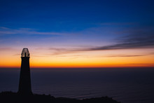 Silhouette Of Lighthouse Against Sea During Sunset