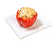 Bell pepper stuffed with meat and vegetables baked with cheese on a square plate isolated on white background