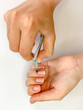 © Alona Gryadovaya - Close up of hands. Self manicure at home trimming cuticles on white background.