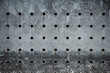 Old metal sheet with evenly drilled round holes