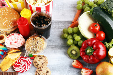 Wall Mural - healthy or unhealthy food. Concept photo of healthy and unhealthy food. Fruits and vegetables vs donuts,sweets and burgers