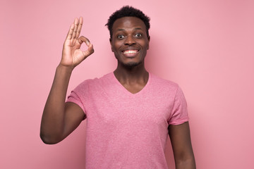 Canvas Print - african american man in pink clothes gesturing OK