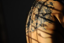 Midsection Of Man Back With Tattoo In Darkroom
