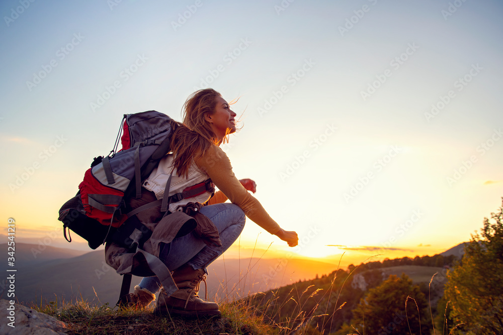 Portrait of happy young woman hiking in the mountains - obrazy, fototapety, plakaty 