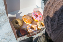 Close-up High Angle View Of Woman Holding Various Donuts In Box